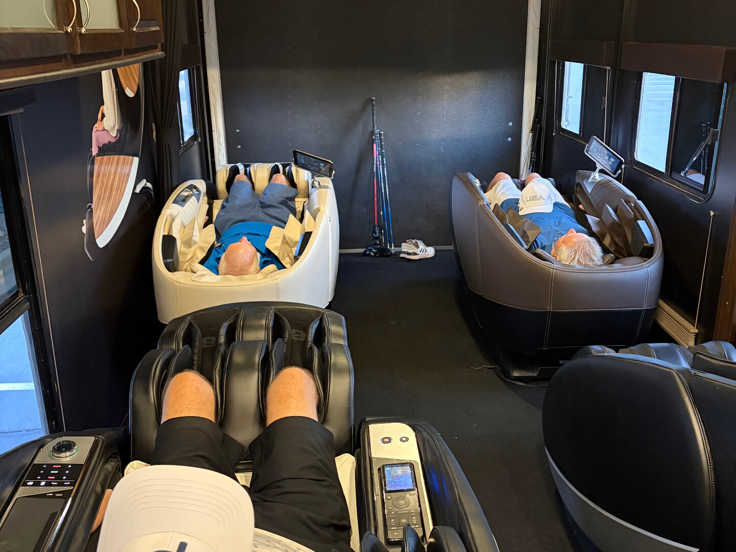 Guests relaxing in massage chairs inside the RV